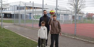 Nathanael Bader setzt sich mit seinen Söhnen David (rechts) und Jonte dafür ein, dass es mehr Begegnungsmöglichkeiten für Familien gibt. Im Hintergrund ist der bei der Realschule gelegene Bolzplatz zu sehen, der zuletzt geschlossen war.